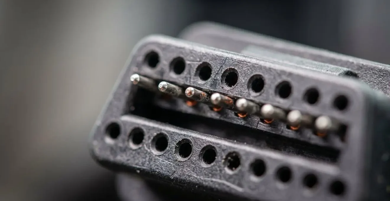 Gros plan extrême sur un connecteur de diagnostic automobile OBD montrant la complexité des circuits électroniques