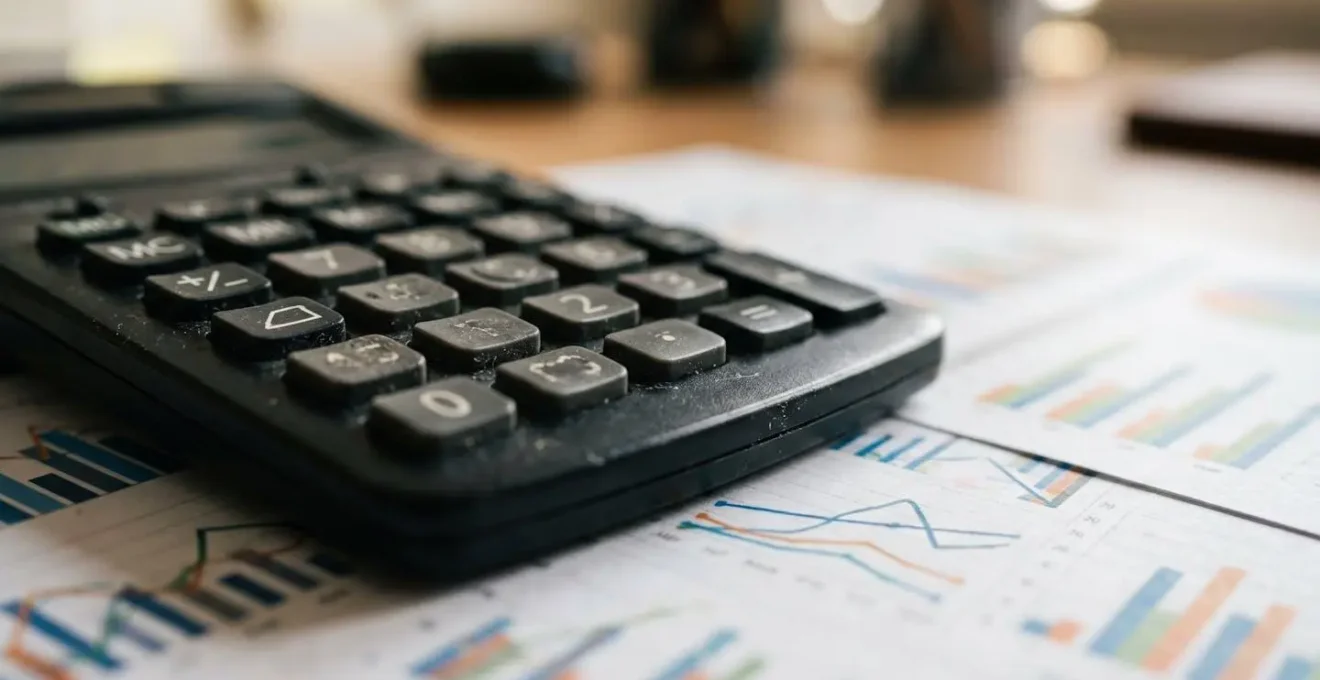 Gros plan sur une calculatrice et des graphiques financiers montrant l'évolution des coûts d'assurance